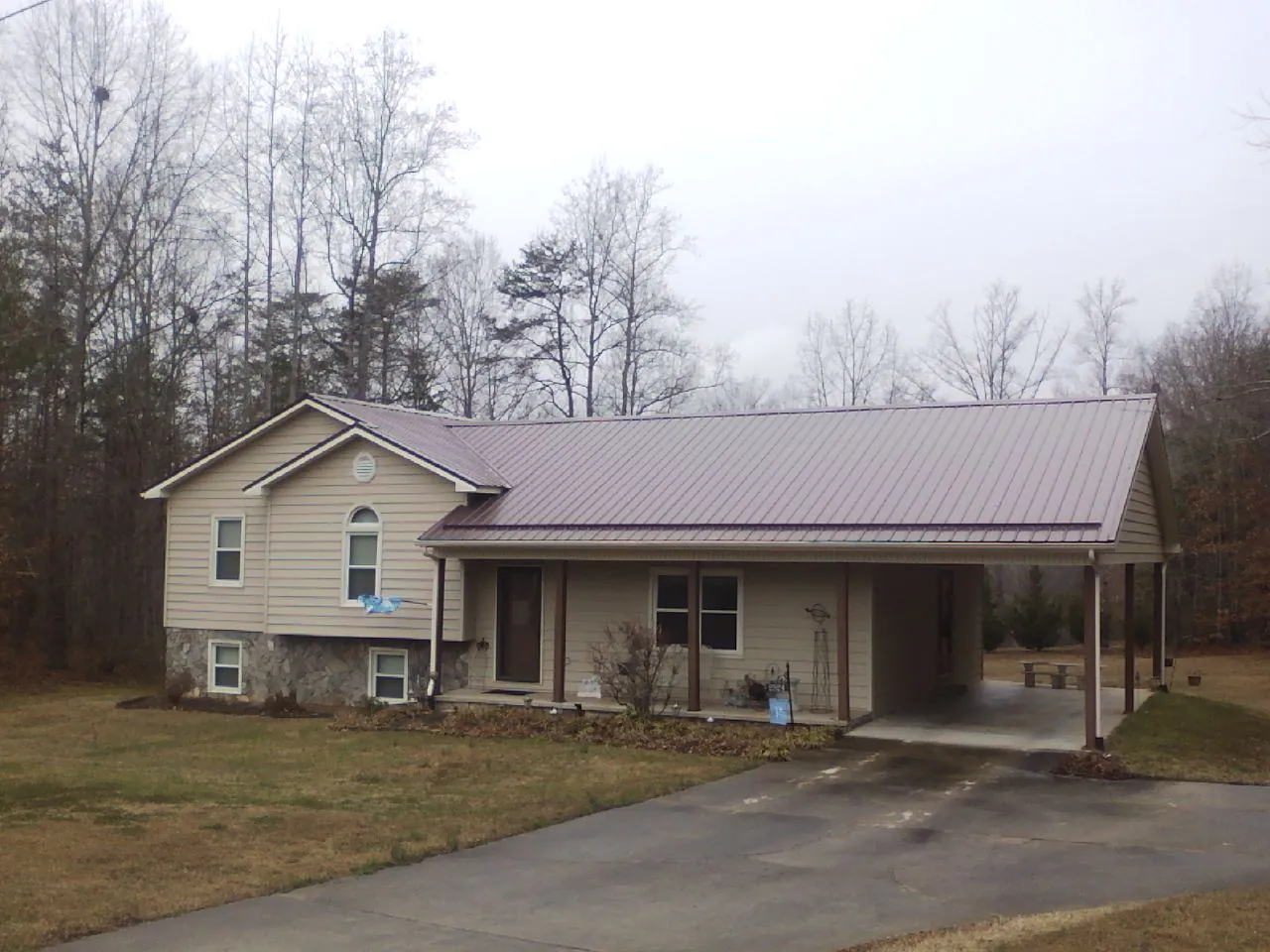 Burgundy metal roof on a tan split level home with an attached carport in Elderton