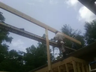 Carpenter setting a ridge beam over a new addition frame — Ice Dam Removal by Roofing Brothers in Elderton