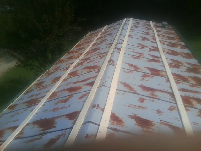 Rusted metal roof panels with new wood purlins before replacement — Storm Damage Roof Repair in Elderton by Roofing Brothers