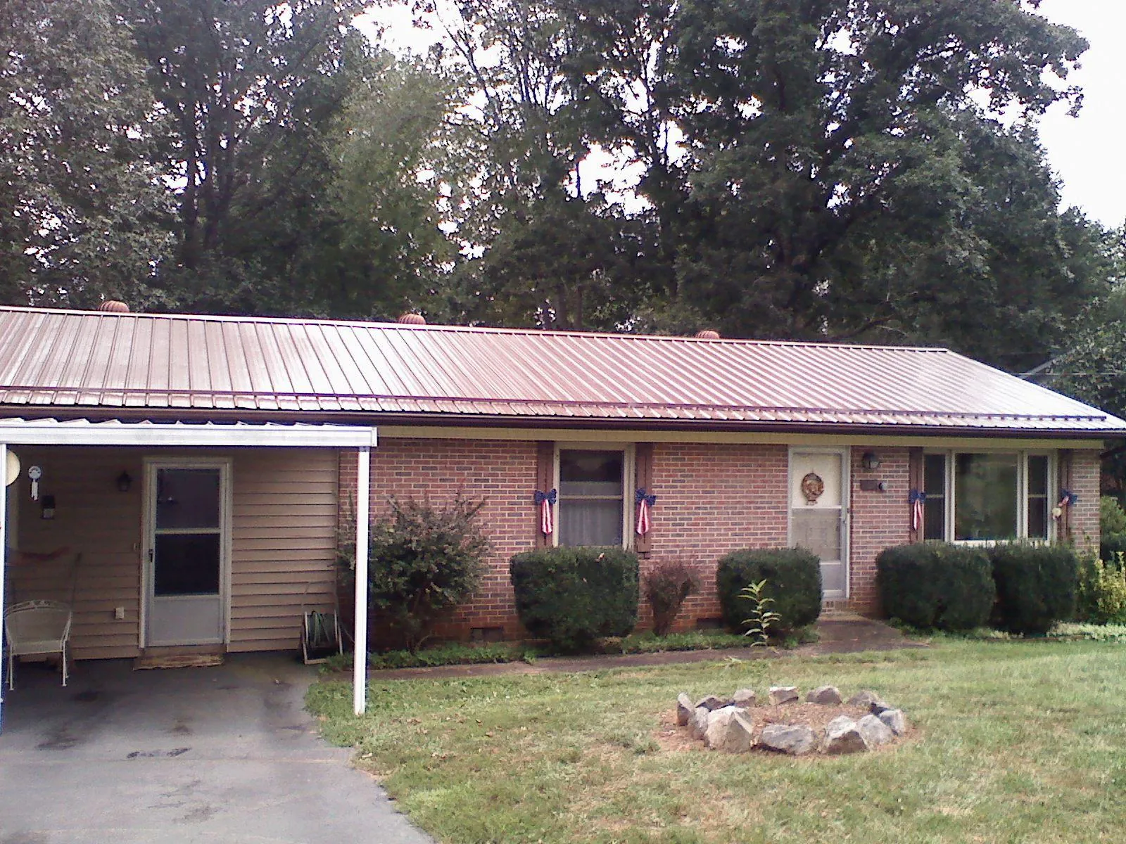Bronze metal roof and carport on a brick ranch home — Roof Repair work by our crew in Elderton